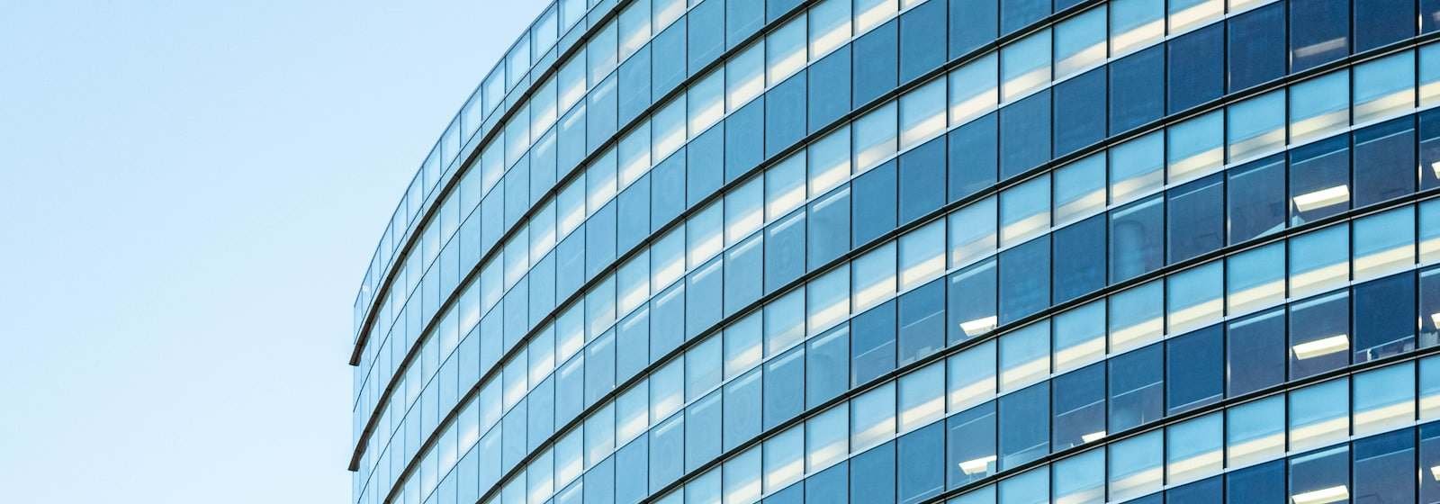 The curved glass facade of a modern office building