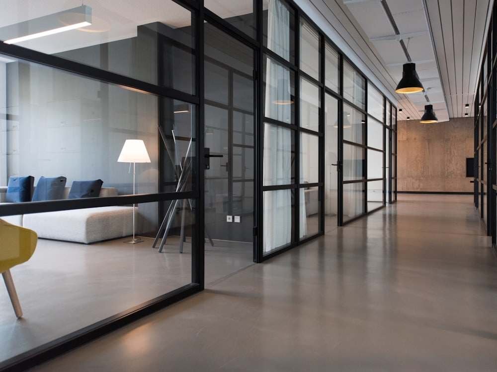 A modern office corridor with glass-walled meeting rooms