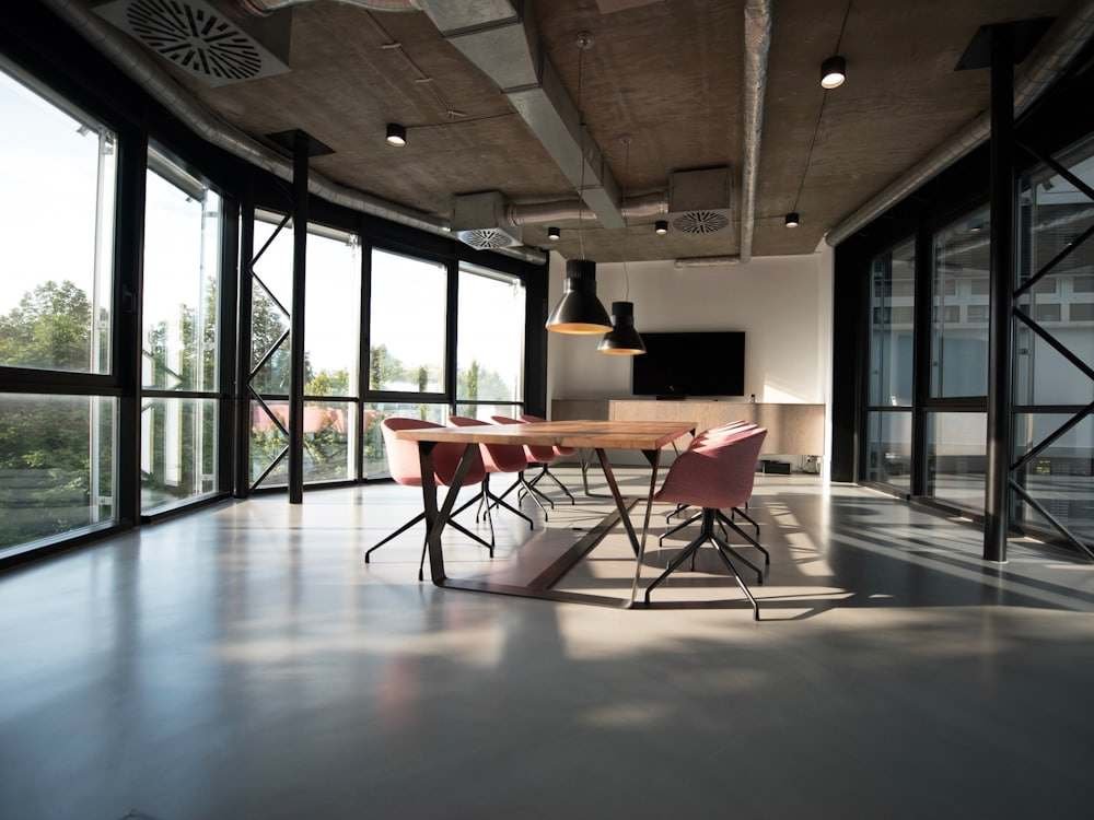 A modern glass-walled meeting room with a long table