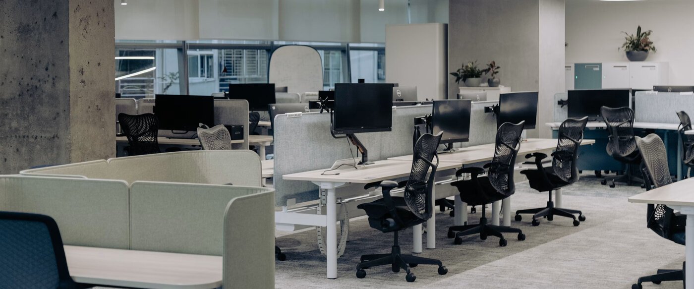 An office floor with around ten workstations side by side