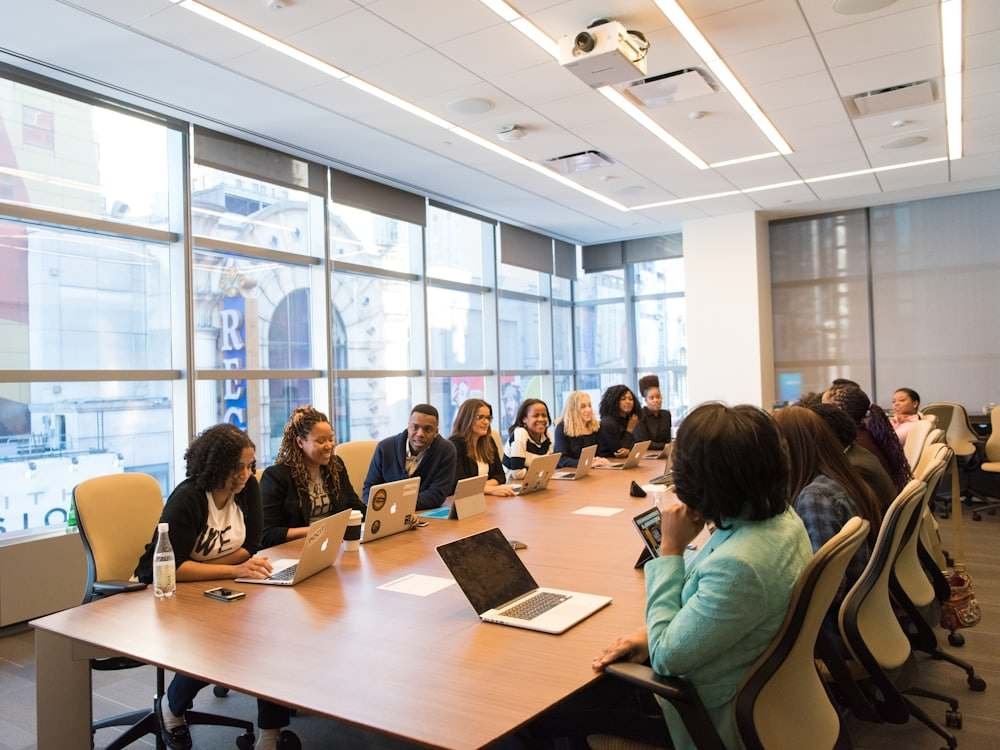 A long meeting table with people working on laptops