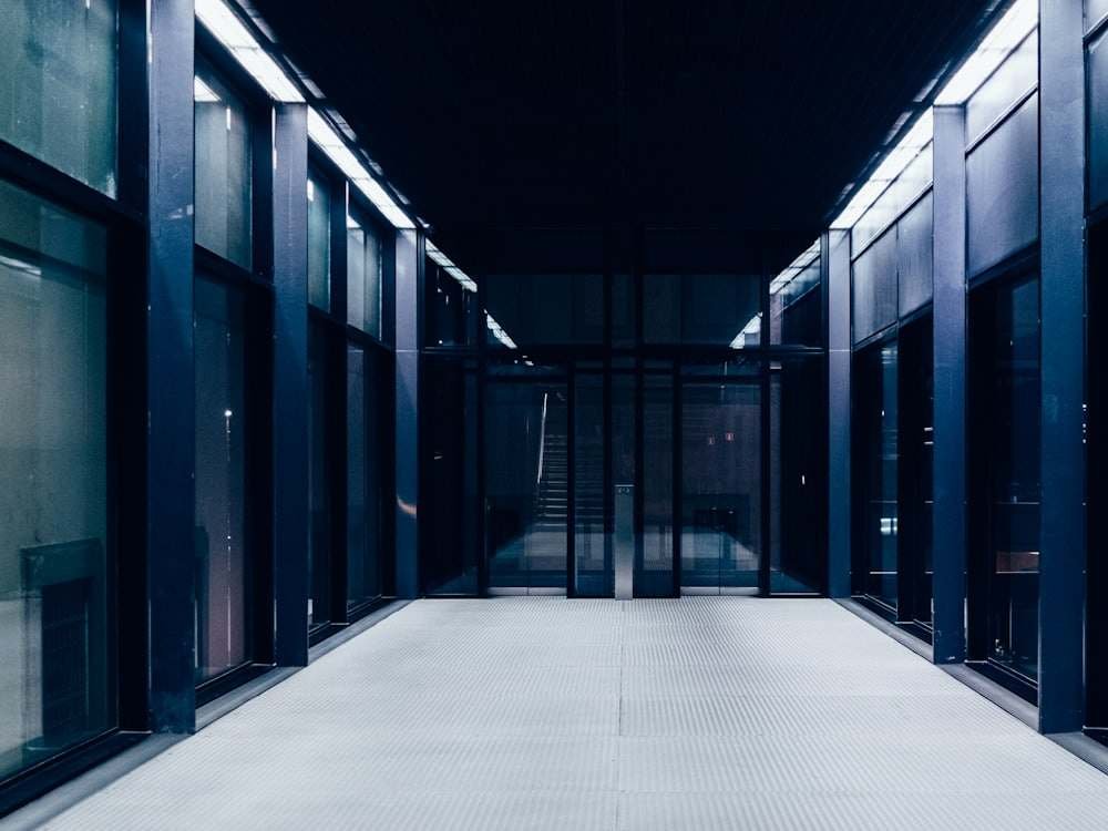 A corridor in a modern data centre, between glass-fronted server cabinets